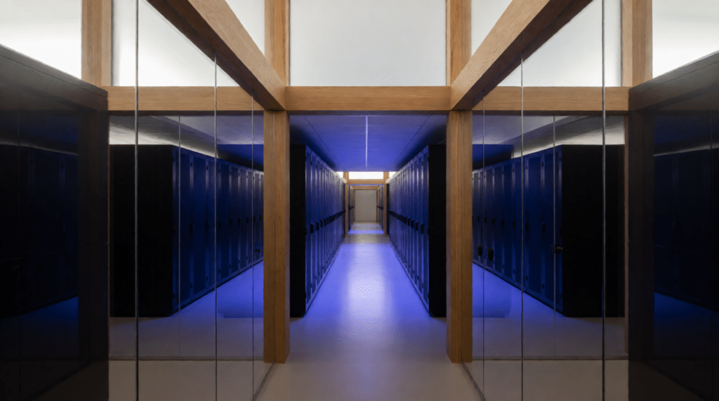 Data centre hall with rows of server cabinets in cool blue light