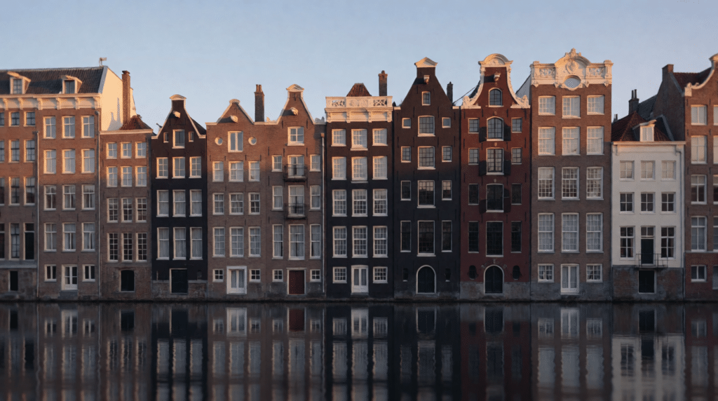 Row of narrow canal houses with varied gables in evening light