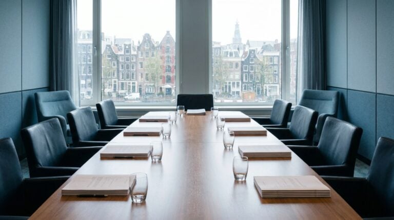 Empty boardroom with meeting documents and a view over Amsterdam canal houses