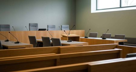An empty Dutch courtroom seen from the public benches before a criminal hearing