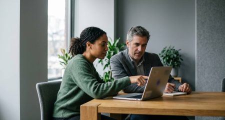 A brand manager and a lawyer reviewing a domain name registration together on a laptop