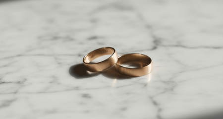 Мәрмәр бетінде бөлек жатқан екі неке жүзігі мүлік даулары мен манипуляциялық мінез-құлыққа байланысты қиын ажырасуды білдіреді.